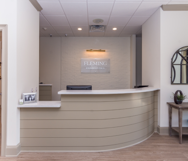Modern dental reception desk with curved counter, warm lighting, and welcoming clinic interior.